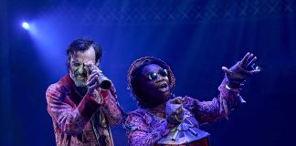 A Christmas Carol – review Paul Hilton (Ebenezer Scrooge) and Kibong Tanji (Ghost of Christmas Present) in A Christmas Carol at The Old Vic (2025). Photo by Manuel Harlan