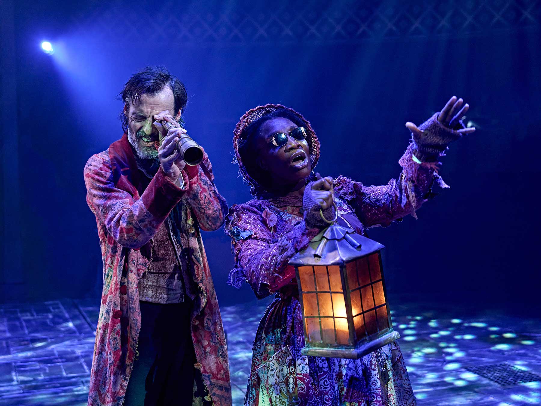 A Christmas Carol - review 1 Paul Hilton (Ebenezer Scrooge) and Kibong Tanji (Ghost of Christmas Present) in A Christmas Carol at The Old Vic (2025). Photo by Manuel Harlan