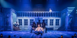 Cyrano de Bergerac – review Levi Brown (Christian de Neuvillette), Rachel Dawson (Ann-Sofie, Cyrano's Band), Oliver Grant (Cyrano’s Band), Josh Sneesby (Raphael, Cyrano’s Band), Adrian Lester (Cyrano), Susannah Fielding (Roxane) in Cyrano de Bergerac (Royal Shakespeare Company) at the Noël Coward Theatre. Photo: © Marc Brenner